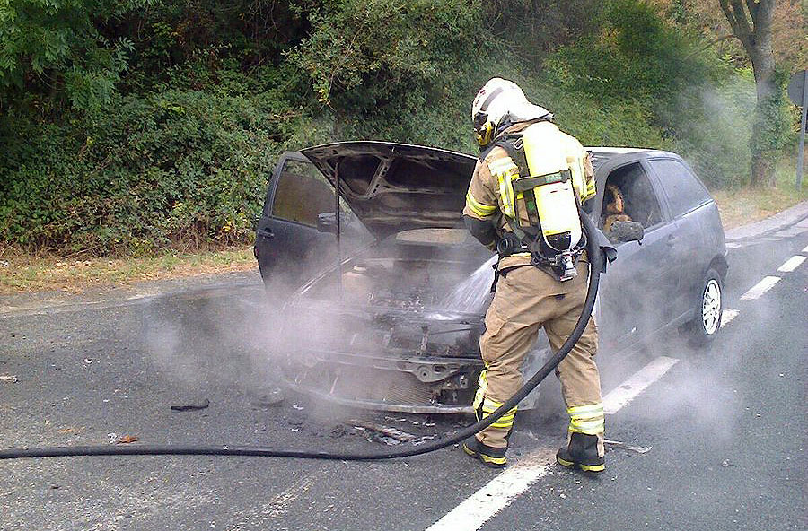 Un bombero sofocando el fuego del coche. (Foto: @Bomberos Bizkaia)