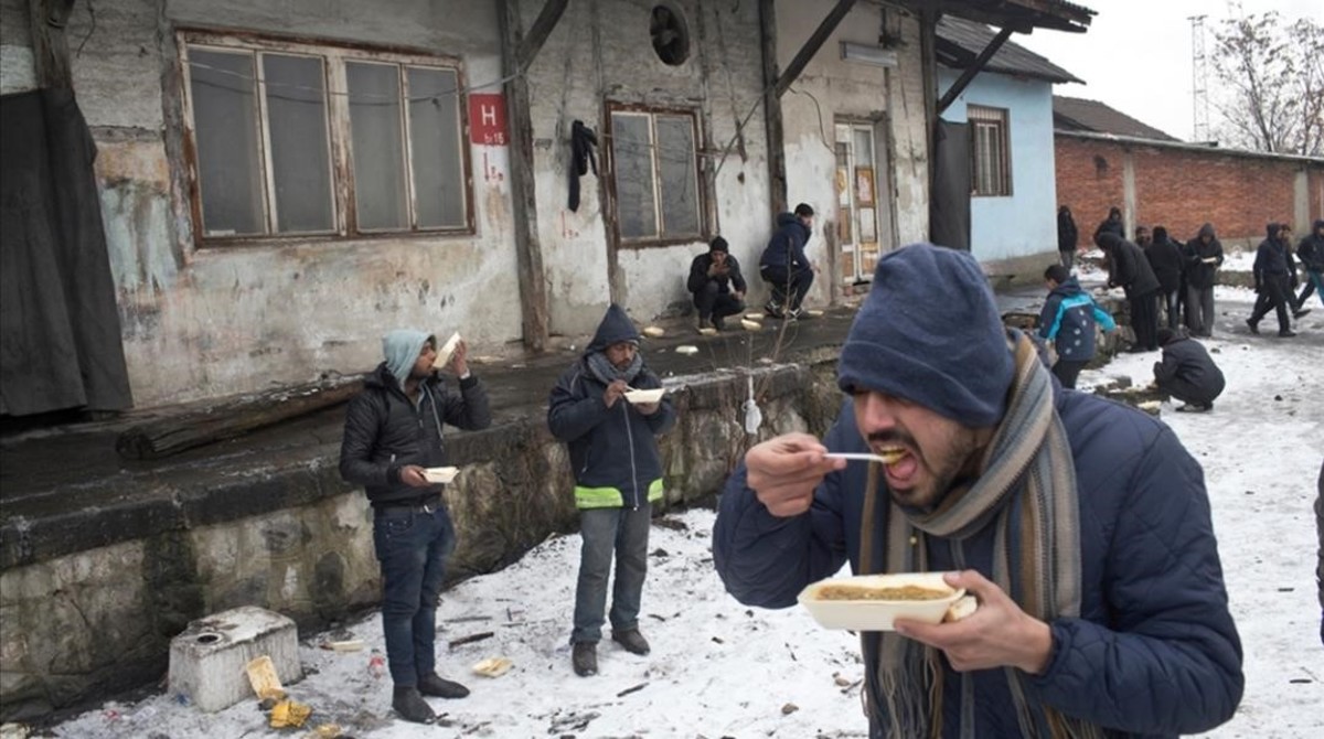Refugiados comiendo en un almacen abandonado en Belgrado Serbia Marko Drobnjakovic